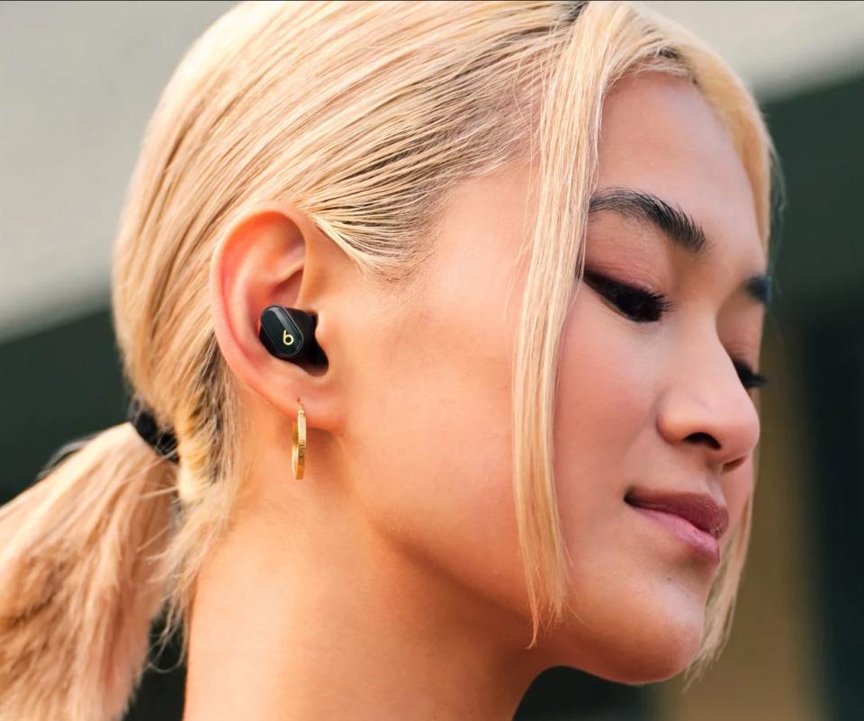 a model wearing the earbuds in black