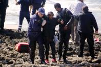 Greek coast guards help a woman rescued after a boat carrying migrants sank off the Greek island of Rhodes on April 20, 2015