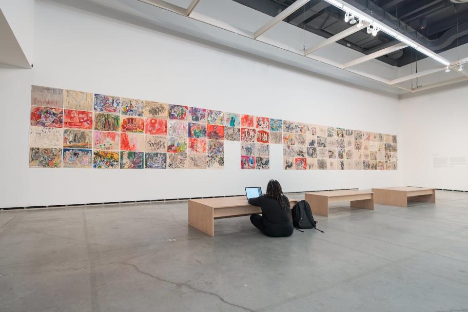 Paulina O'Kieffe-Anthony works on her KUUMBA 365 presentation at the festival exhibit, "Time of Change" by Anna Boghiguian.