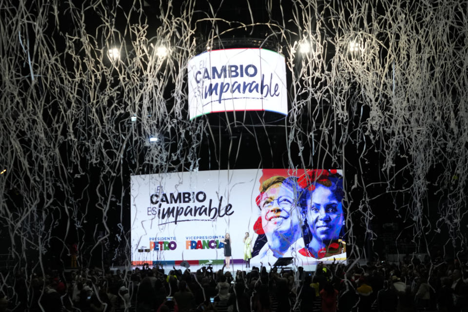 Confetti explode over a screen showing photos of presidential candidate Gustavo Petro, left, and his running mate Francia Marquez after they won a runoff election at their election night headquarters in Bogota, Colombia, Sunday, June 19, 2022. (AP Photo/Fernando Vergara)