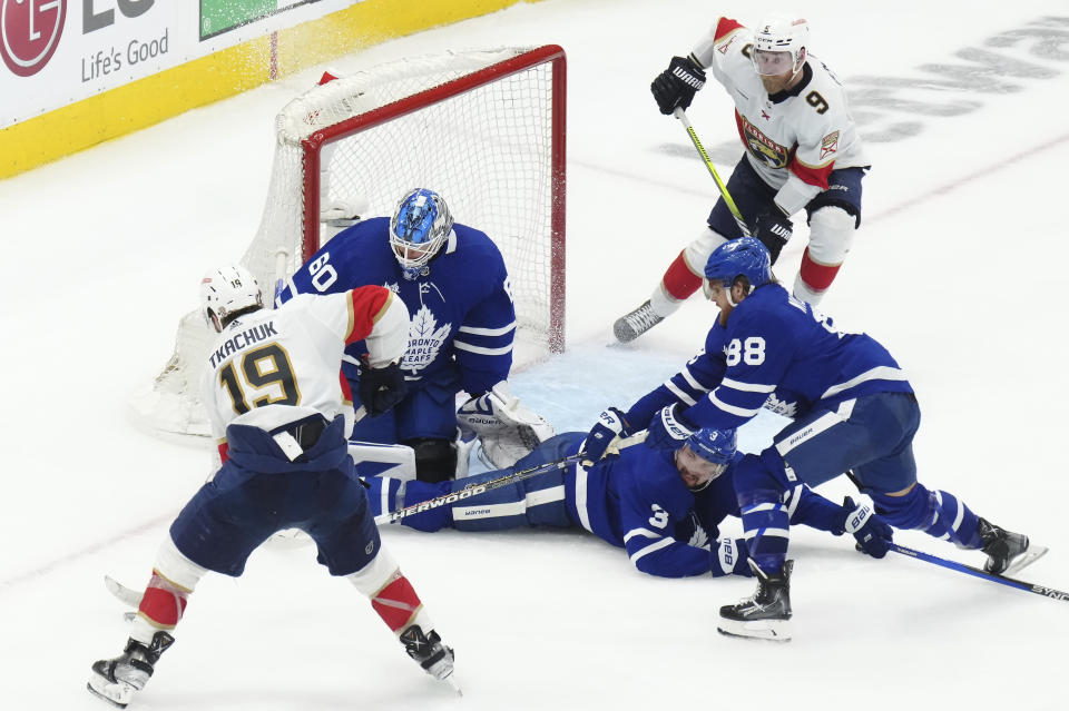 Toronto Maple Leafs goaltender Joseph Woll (60) looks to make a save on Florida Panthers forward Matthew Tkachuk (19) as Maple Leafs defenseman Justin Holl (3) and forward William Nylander (88) watch during overtime in Game 5 of an NHL hockey Stanley Cup second-round playoff series Friday, May 12, 2023, in Toronto. (Chris Young/The Canadian Press via AP)