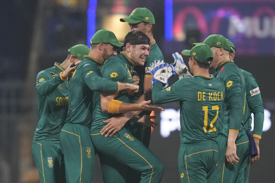 South Africa's Gerald Coetzee, center without cap, celebrates with teammates after the dismissal of England's Harry Brook during the ICC Men's Cricket World Cup match between South Africa and England in Mumbai, India, Saturday, Oct. 21, 2023. (AP Photo/ Rafiq Maqbool)