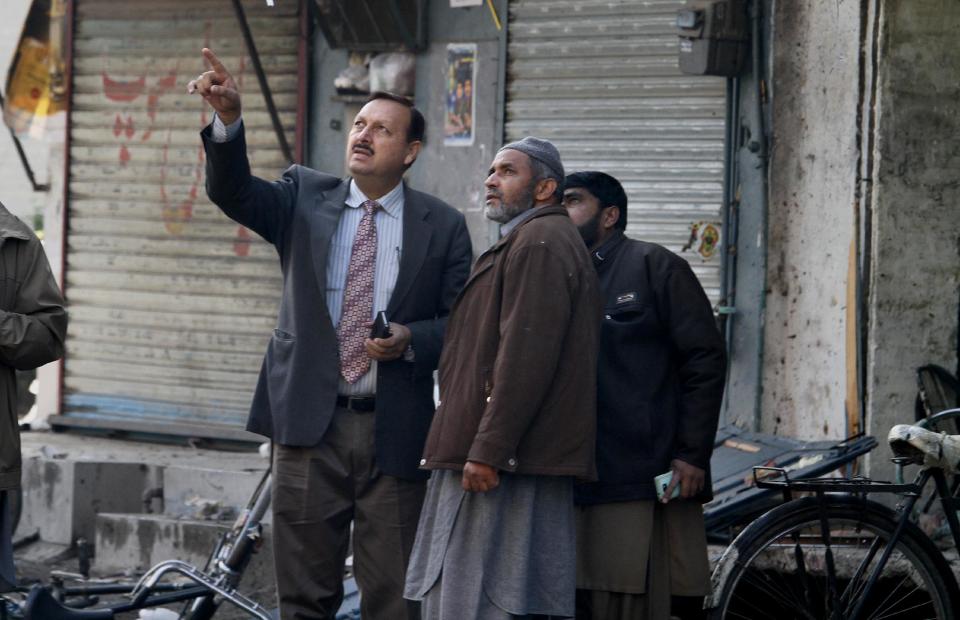 Pakistani investigators survey the site of suicide bombing in Rawalpindi, Pakistan on Monday, Jan. 20, 2014. A suicide bomber blew himself up not far from Pakistan's military headquarters Monday, killing some people a day after a Taliban bombing inside an army compound in the northwest of the country killed many troops, officials and militants said. (AP Photo/Anjum Naveed)