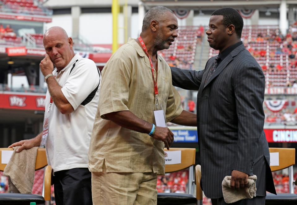 Former Cincinnati Reds players, left to right, Ron Oester, Dave Parker and Ken Griffey Jr. stand after Parker spoke at ceremonies inducting the three players into the Reds Hall of Fame, Saturday, Aug. 9, 2014, prior to a baseball game against the Miami Marlins in Cincinnati.
