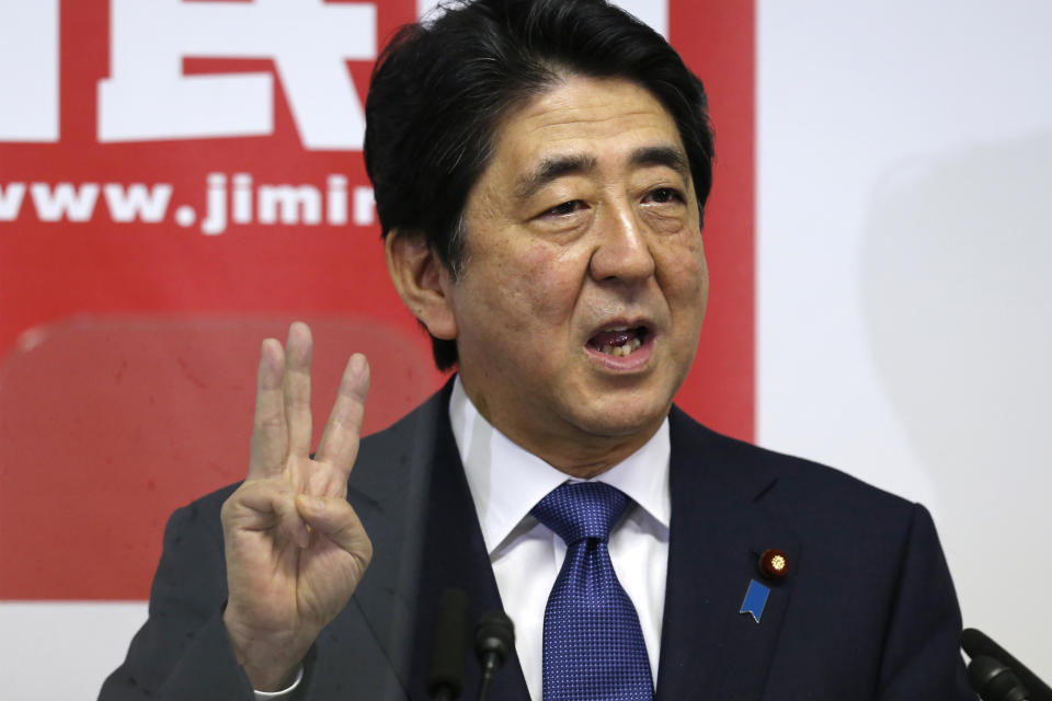 FILE - Japanese Prime Minister Shinzo Abe explains about "three arrows" of his "Abenomics" plan during a press conference at the headquarters of his ruling Liberal Democratic Party in Tokyo on Sept. 24, 2015. Seeking to boost growth, Abe launches his “Abenomics” policies featuring easy lending and structural reforms. (AP Photo/Shuji Kajiyama, File)