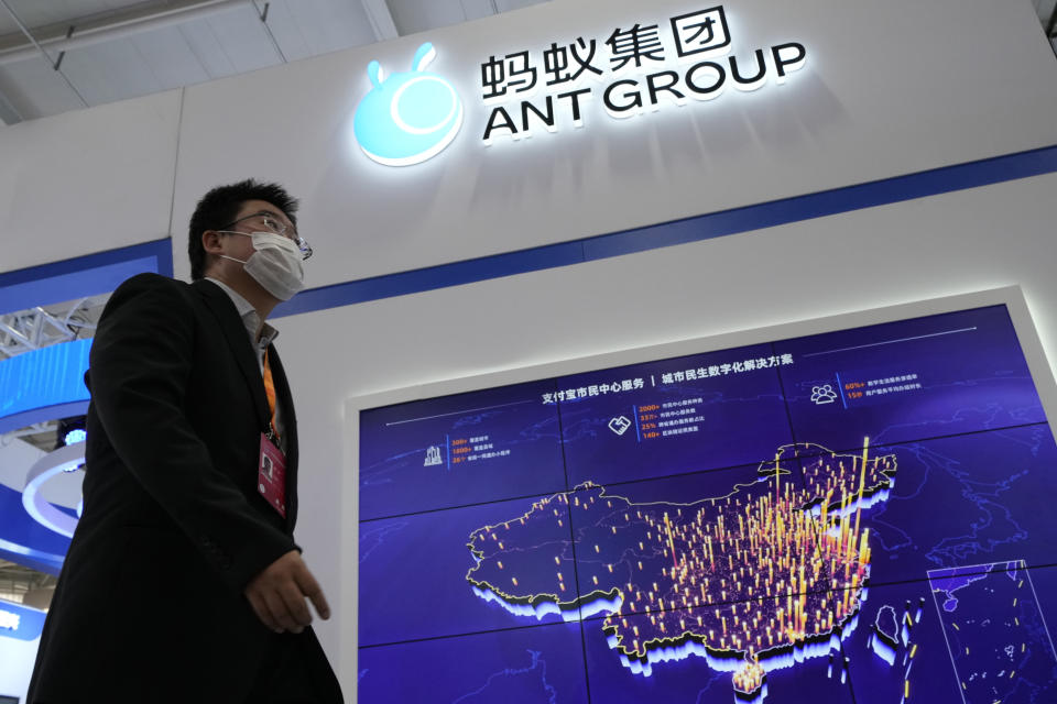 A visitor to a trade fair pasts by the Ant Group booth in Beijing, China, Monday, Sept. 6, 2021. China's central bank will soon have access to private credit information of hundreds of millions of users of Ant Group's online credit service, in a move signaling more regulatory oversight of the financial technology sector. (AP Photo/Ng Han Guan)