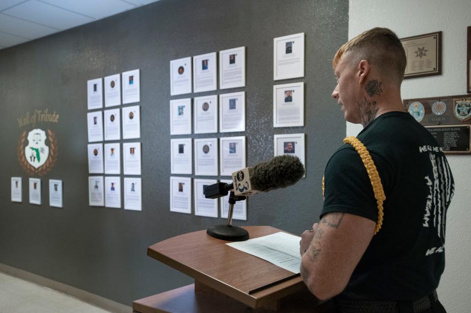 Corrections officer trainee Matthew Wester reads the names of fallen law enforcement officers during a ceremony dedicating the new Wall of Tribute in their honor at the George Stone Criminal Justice Training Center in Pensacola on Tuesday. The wall honoring fallen officers from the four area counties was created by the 118th class of corrections officer trainees.