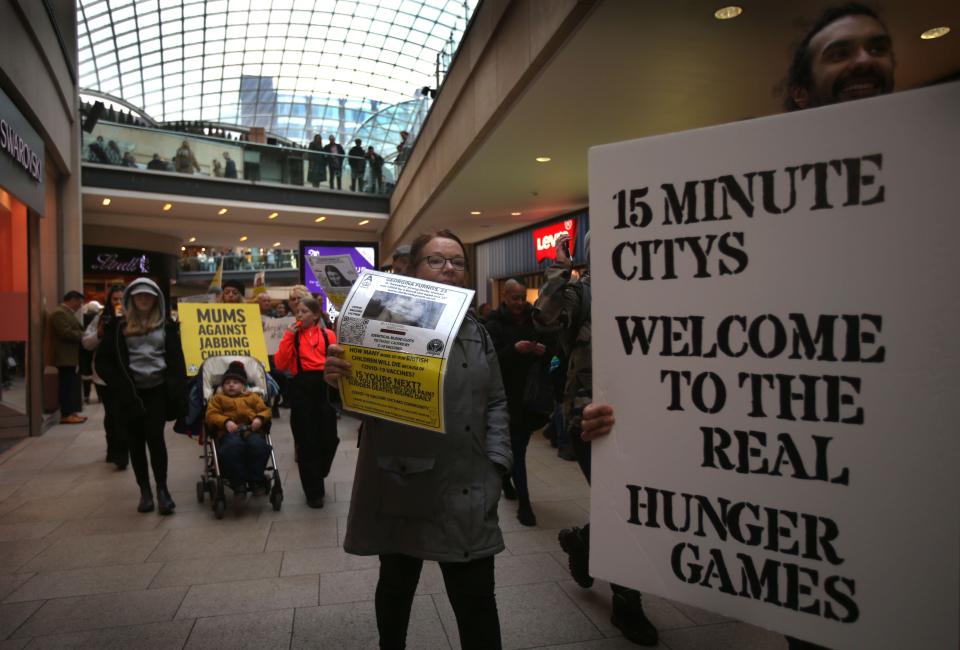 Leeds, West Yorkshire, UK. 11th Feb, 2023. Protesters carry placards through the shopping mall warning of 15 minute cities and the covid-19 jab. Freedom campaigners march across the city centre and demonstrate outside media companies. The 