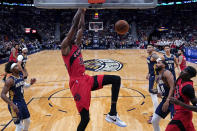 Toronto Raptors forward Christian Koloko (35) slam dunks over New Orleans Pelicans forward Garrett Temple (41) and guard Devonte' Graham (4) in the first half of an NBA basketball game in New Orleans, Wednesday, Nov. 30, 2022. (AP Photo/Gerald Herbert)