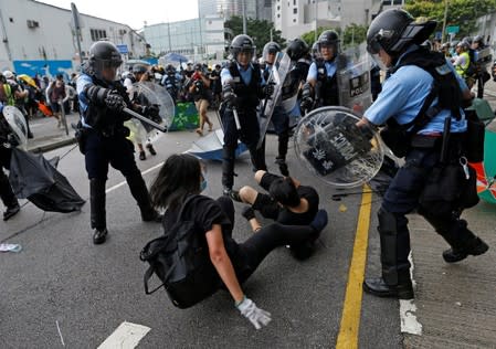 Riot police try to disperse protesters near a flag raising ceremony for the anniversary of Hong Kong handover to China in Hong Kong