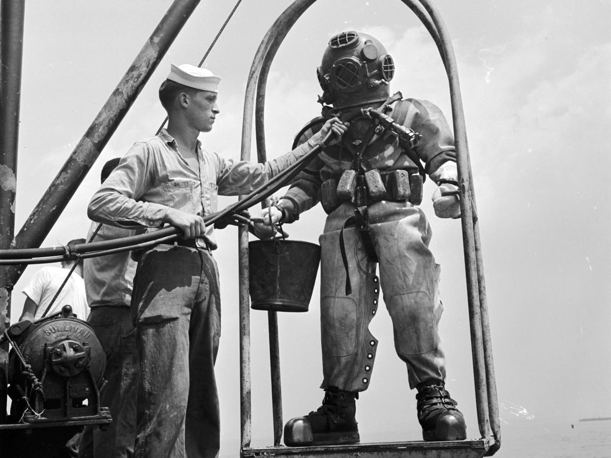 A US navy diver on a ‘diving stage’ before a dive in 1955.