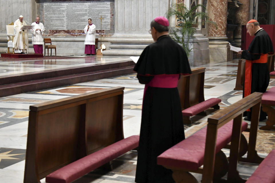 Pope Francis, left, leads a Mass for Holy Thursday, inside St. Peter's Basilica at the Vatican, Thursday, April 9, 2020. Francis celebrated the Holy Week Mass in St. Peter's Basilica, which was largely empty of faithful because of restrictions aimed at containing the spread of COVID-19. The new coronavirus causes mild or moderate symptoms for most people, but for some, especially older adults and people with existing health problems, it can cause more severe illness or death. (Alessandro Di Meo/Pool Photo via AP)