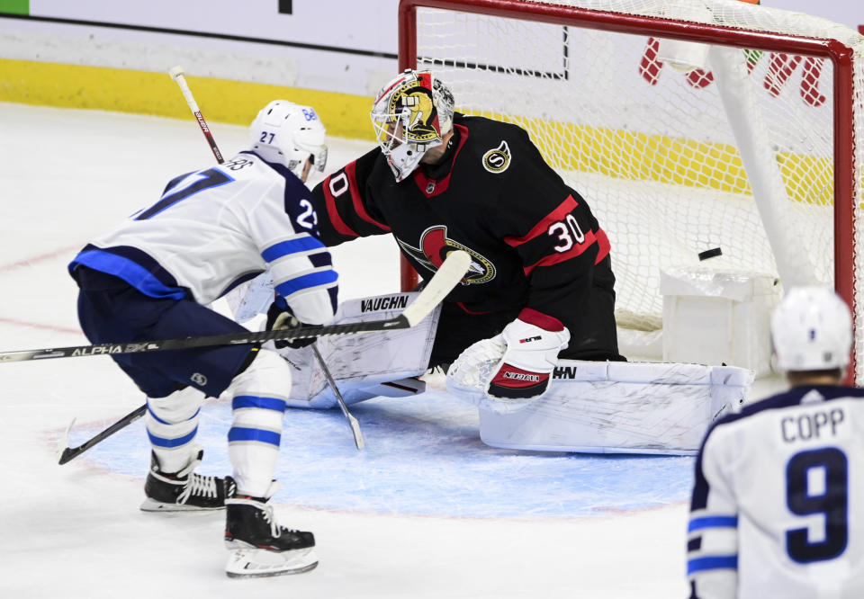 Winnipeg Jets left wing Nikolaj Ehlers (27) scores the game-winning goal past Ottawa Senators goaltender Matt Murray (30) during overtime of an NHL game in Ottawa, Ontario, on Tuesday, Jan. 19, 2021. (Sean Kilpatrick/The Canadian Press via AP)