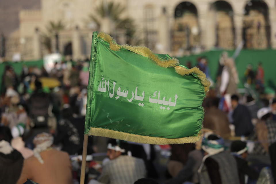 FILE - In this Nov. 9, 2019 file photo, a supporter of Shiite rebels, known as Houthis, holds a banner with Arabic writing that reads, "at your order, oh messenger of Allah," during a celebration of Mawlid al-Nabi the birth of Islam's prophet Muhammad in Sanaa, Yemen. A satellite TV channel run by Yemen’s Houthi rebels has broadcast on Thursday, Oct. 15, 2020, the start of a long-awaited prisoner exchange between the country’s warring sides. (AP Photo/Hani Mohammed, File)