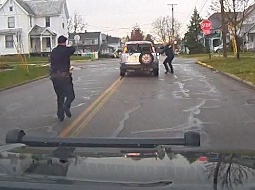 Bucyrus police Officer Devin Wireman, right, and Lt. Scott Bursby, left, approach the suspect's SUV during a Nov. 11 shooting incident in this screen capture from a Bucyrus Police Department video.