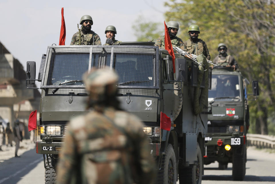 In this Sunday, April 21, 2019, photo, an Indian soldier stands guard as an army convoy moves during a biweekly ban on the movement of civilian vehicles for the safe passage of Indian security force convoy on a key highway on the outskirts of Srinagar, Indian controlled Kashmir. As part of India’s crackdown on dissent in Kashmir, New Delhi has done something unprecedented: it banned civilian vehicles from the only major highway connecting the heart of the disputed Himalayan region with the rest of India, citing unspecified security threats. (AP Photo/Mukhtar Khan)
