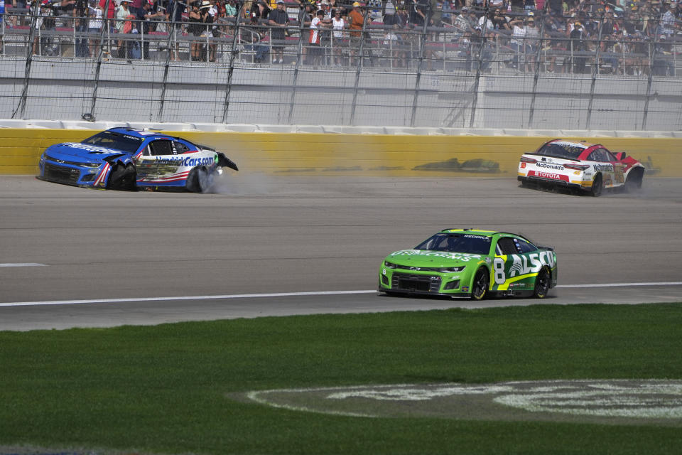 Kyle Larson, left, and Bubba Wallace, right, crash during a NASCAR Cup Series auto race Sunday, Oct. 16, 2022, in Las Vegas. (AP Photo/John Locher)