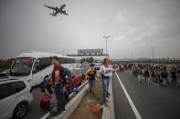 Protesters block the roads leading to El Prat airport, outskirts of Barcelona, Spain, Monday, Oct. 14, 2019. Spain's Supreme Court on Monday sentenced 12 prominent former Catalan politicians and activists to lengthly prison terms for their roles in a 2017 bid to gain Catalonia's independence, sparking protests across the wealthy Spanish region. The banners in the center read in Catalan "Freedom Political Prisoners" (AP Photo/Bernat Armangue)