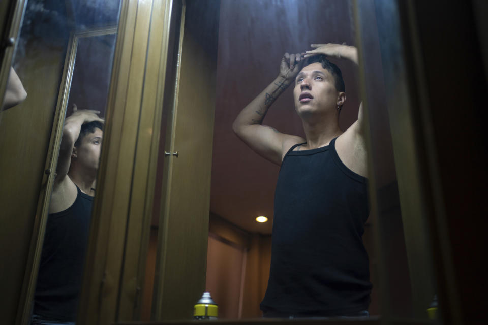 News anchor Guillermo Barraza combs his hair as he gets ready to go to work, at his home in Mexico City, Wednesday, Oct. 11, 2023. Growing up gay in the hyper-conservative northern city of Culiacán, Sinaloa, Barraza never saw gay characters he identified with on a deeper level staring back at him from the screen of his family’s television. (AP Photo/Aurea Del Rosario)