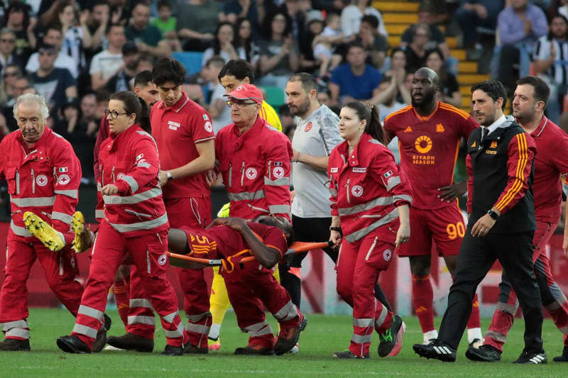 Rome's Evan Ndicka (C) is carried off the pitch by paramedics after a medical emergency during the Italian serie A soccer match between Udinese Calcio and AS Rom at Bluenergy Stadium. Andrea Bressanutti/LaPresse via ZUMA Press/dpa