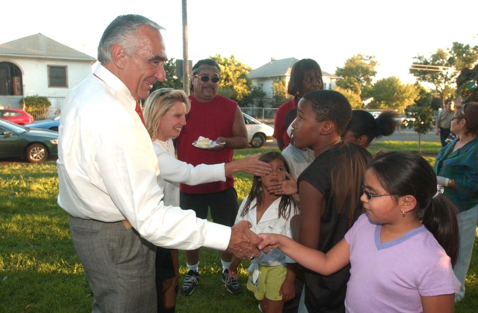 Stockton Mayor Gary Podesto and his wife Janice shakes hands with neighborhood children at the National Night Out event held at Columbus Park in Stockton on Aug. 5, 2003.
