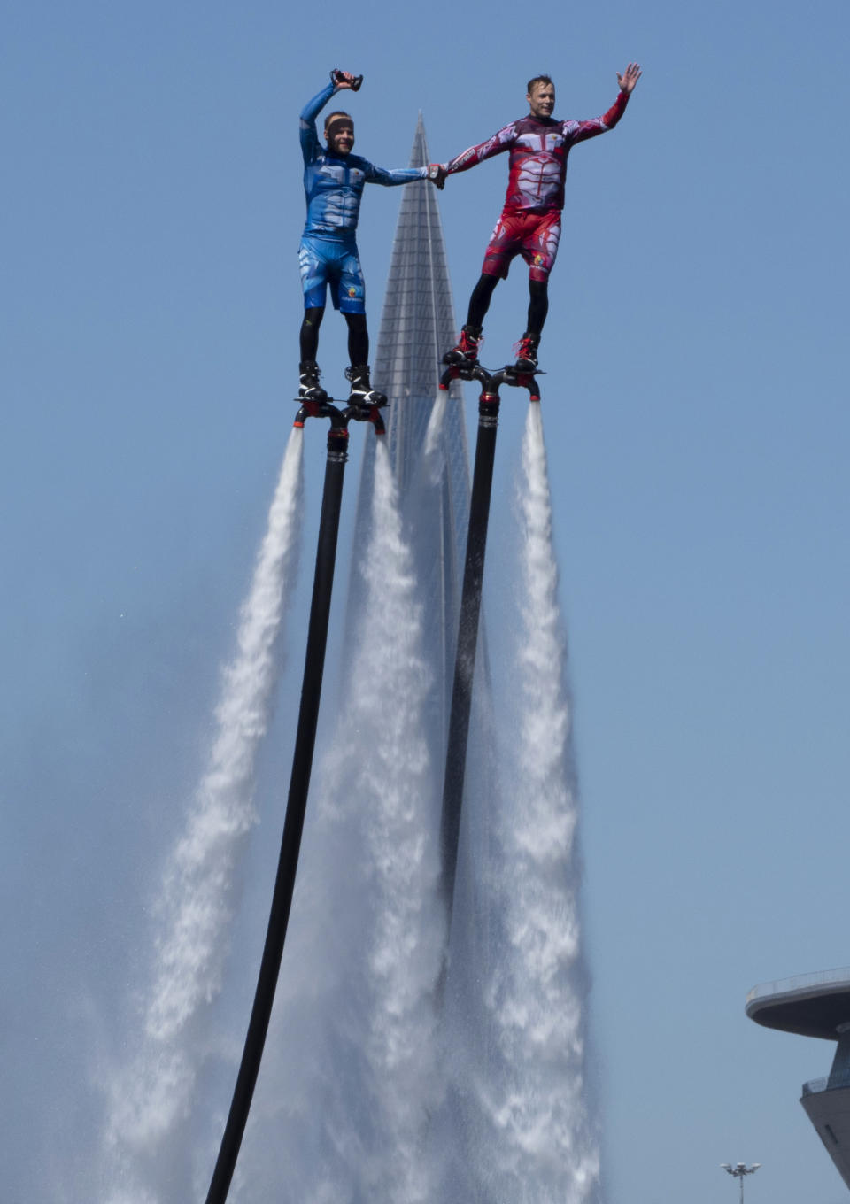 Members of the Russian hydroflight team perform during the Day of Russia celebration in St.Petersburg, Russia, Friday, June 12, 2020, with business tower Lakhta Centre, the headquarters of Russian gas monopoly Gazprom in the background. (AP Photo/Dmitri Lovetsky)