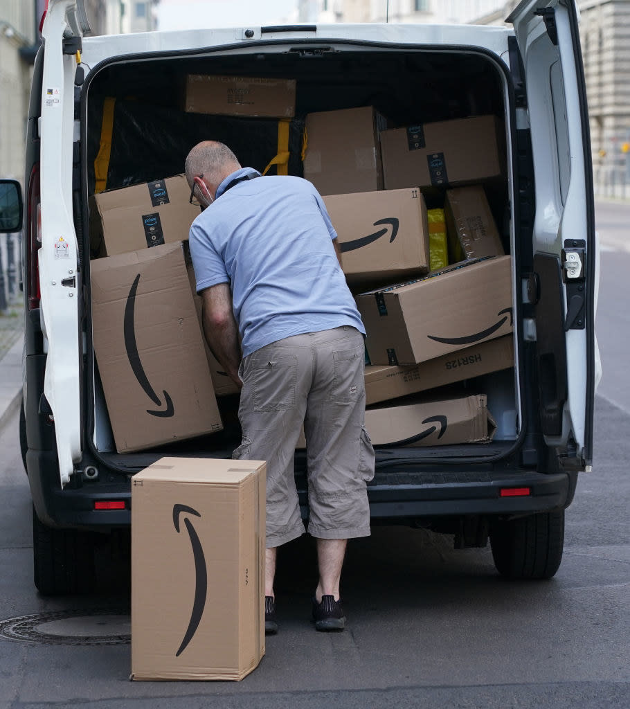 delivery man unloading a van full of amazon packages