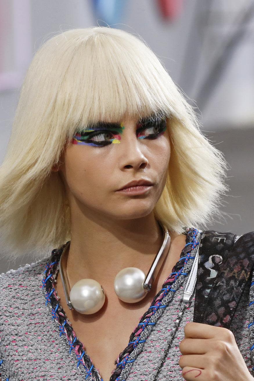 Model Cara Delevingne presents a creation as part of Chanel's ready-to-wear Spring/Summer 2014 fashion collection, presented Tuesday, Oct. 1, 2013 in Paris. (AP Photo/Jacques Brinon)