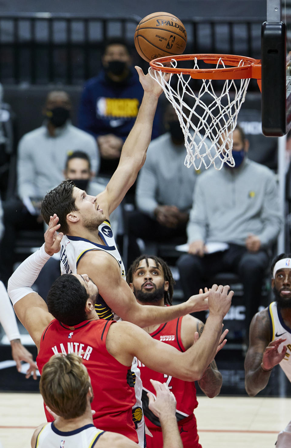Indiana Pacers forward Doug McDermott, center, shoots between Portland Trail Blazers center Enes Kanter, left, and guard Gary Trent Jr. during the first half of an NBA basketball game in Portland, Ore., Thursday, Jan. 14, 2021. (AP Photo/Craig Mitchelldyer)