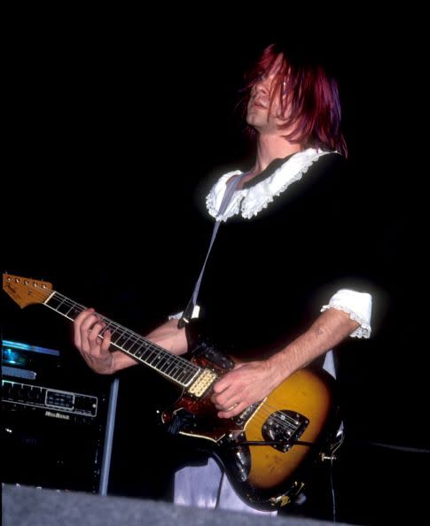 <p>Kurt Cobain in concert at the Forum in Los Angeles, California in 1991. The band name "Nirvana" was taken from a Buddhist concept which Cobain described as "freedom from pain, suffering and the external world." He often utilized religious elements and imagery in his work.</p>