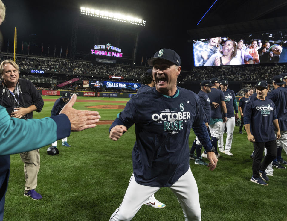 Seattle Mariners manager Scott Servais celebrates after the team's baseball game against the Oakland Athletics, Friday, Sept. 30, 2022, in Seattle. The Mariners won 2-1 to clinch a spot in the playoffs. (AP Photo/Stephen Brashear)