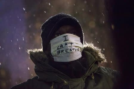 A man stands in falling snow following a news conference where members of Justice League NYC presented a list of demands at City Hall in New York December 10, 2014. REUTERS/Andrew Kelly