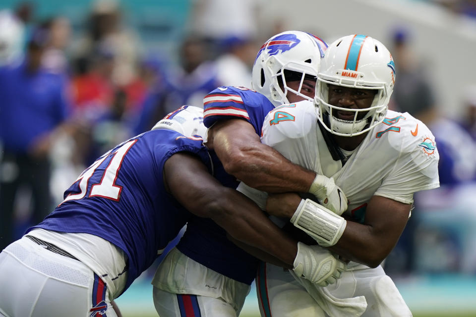 Miami Dolphins quarterback Jacoby Brissett (14) is sacked by Buffalo Bills outside linebacker Matt Milano (58), back, and Buffalo Bills defensive tackle Ed Oliver (91), second left, during the first half of an NFL football game, Sunday, Sept. 19, 2021, in Miami Gardens, Fla. (AP Photo/Wilfredo Lee)