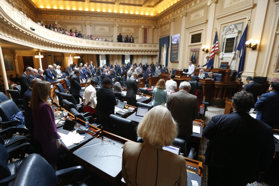 Members of the Virginia House of Delegates, stand to agree to honor the victims of the Virginia Beach shootings during the Special session on gun issues at the State Capitol in Richmond, Va., Tuesday, July 9, 2019. Governor Northam called a special session of the General Assembly to consider gun legislation in light of the Virginia Beach Shootings both chambers voted to adjourn until Nov. 18. (AP Photo/Steve Helber)