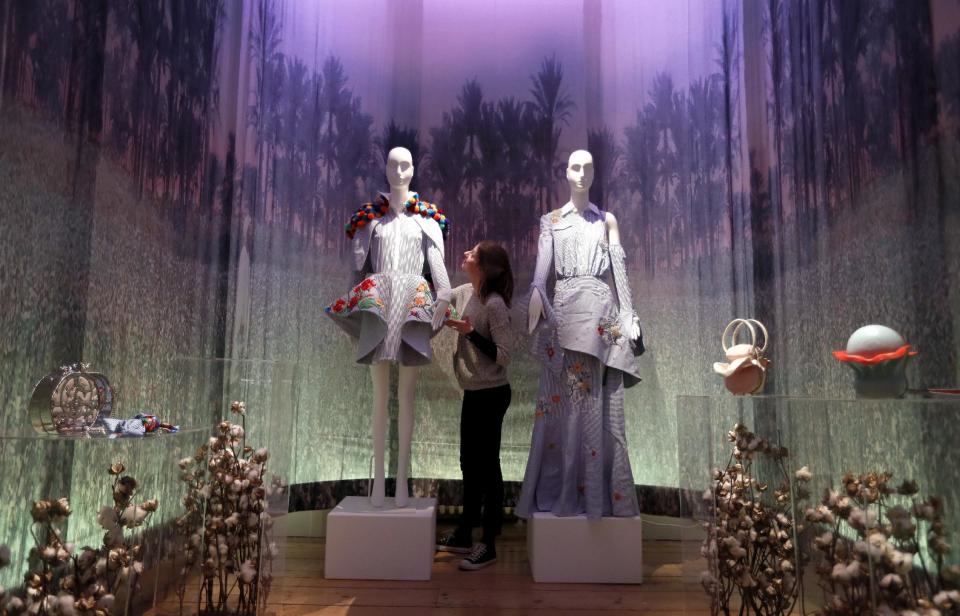 Exhibition assistant Monique Ricketts puts finishing touches to a display by Egyptian fashion designers at Somerset House in London, Thursday, Feb. 16, 2017. The designs from 26 countries are displayed at the International Fashion Showcase 2017, presented by the British Council and British Fashion Council, supported by Mercedes Benz. (AP Photo/Kirsty Wigglesworth)