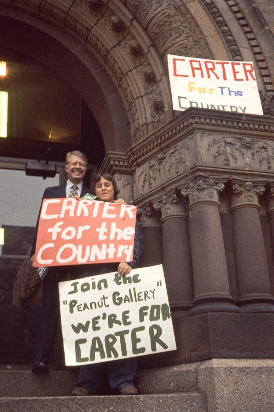 Presidential candidate Jimmy Carter poses with an unidentified supporter during a campaign event in Brockon, Massachusetts, in 1976.