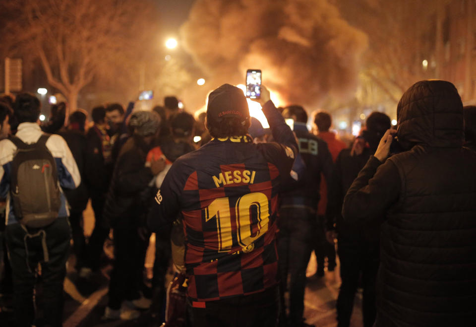Un hombre toma fotos de fogatas durante una protesta en favor de la independencia catalana afuera del estadio Camp Nou en Barcelona, España, el miércoles 18 de diciembre de 2019. (AP Foto/Joan Mateu)