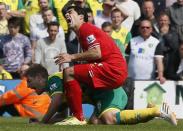 Liverpool's Luis Suarez (R) is fouled by Norwich City's Michael Turner during their English Premier League soccer match at Carrow Road in Norwich, April 20, 2014. REUTERS/Stefan Wermuth