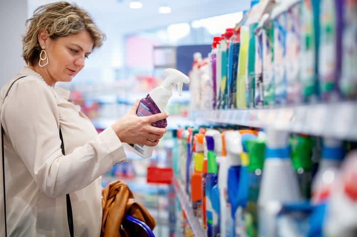 A person shopping for cleaning products in a store. 