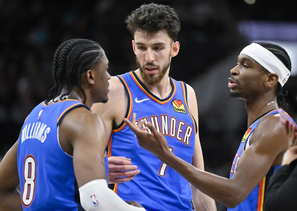 Oklahoma City Thunder's Jalen Williams (8), Chet Holmgren, center, and Shai Gilgeous-Alexander, right, speak during the second half of an NBA basketball game against the San Antonio Spurs, Thursday, Feb. 29, 2024, in San Antonio. (AP Photo/Darren Abate)