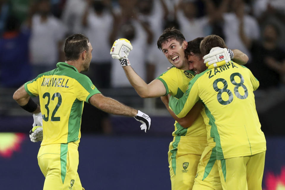 Australia's Glenn Maxwell, left, celebrates hitting a four to win the tournament, with his teammate Mitchell Marsh, second left, and Adam Zampa, 88, in the Cricket Twenty20 World Cup final match between Australia and New Zealand in Dubai, UAE, Sunday, Nov. 14, 2021. Australia won by 8 wickets. (AP Photo/Kamran Jebreili)