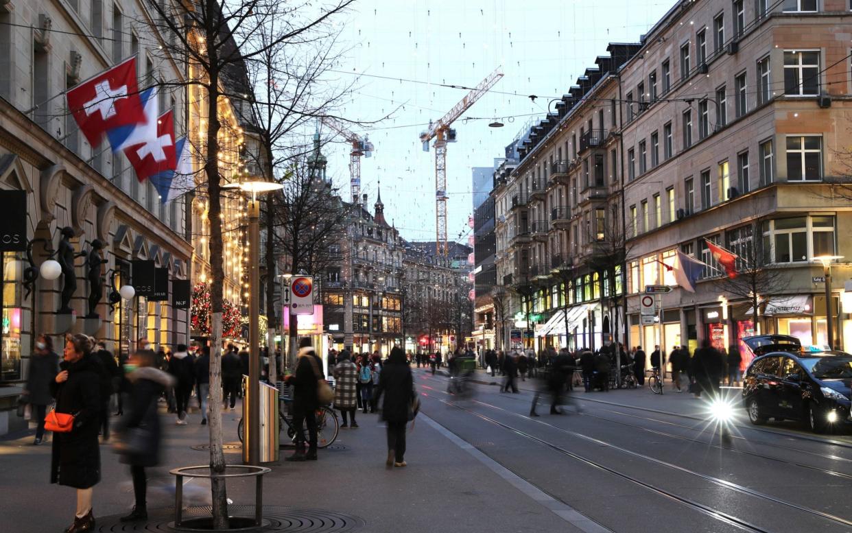 People walk under Christmas illuminations, as the spread of the coronavirus disease (COVID-19) continues, on Bahnhofstrasse shopping street in Zurich, Switzerland November 28, 2020. Picture taken with long exposure. REUTERS/Arnd Wiegmann -  ARND WIEGMANN/REUTERS