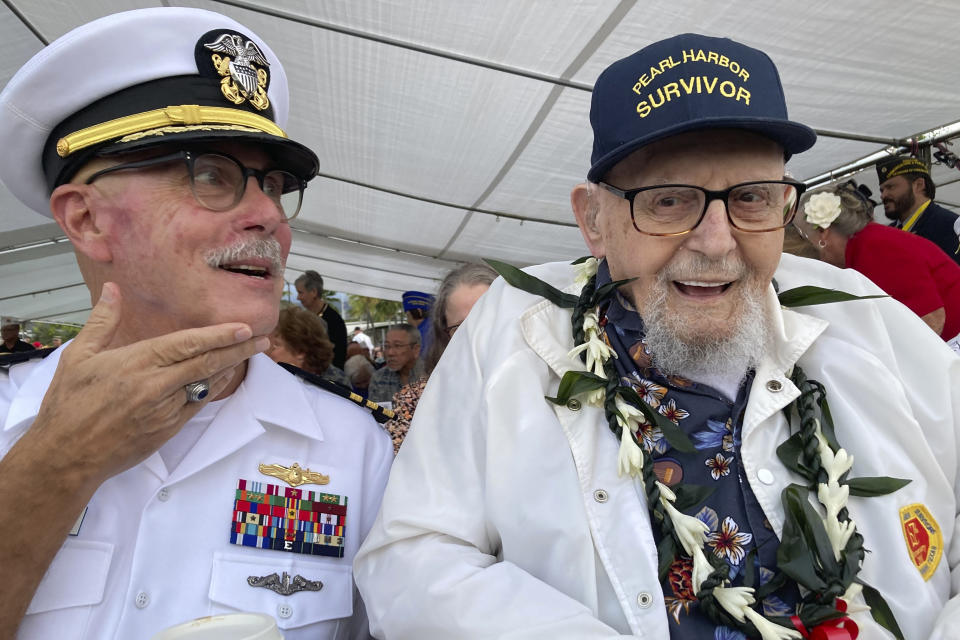 FILE - Ira Schab, right, who survived the attack on Pearl Harbor as a sailor on the USS Dobbin, talks with reporters while sitting next to his son, retired Navy Cmdr. Karl Schab, on Dec. 7, 2022, in Pearl Harbor, Hawaii. Eighty-two years later, Schab plans to return to Pearl Harbor on the anniversary of the attack to remember the more than 2,300 servicemen killed. He's expected to be one of just six survivors at the ceremony commemorating the event that propelled the United States into World War II. (AP Photo/Audrey McAvoy, File)