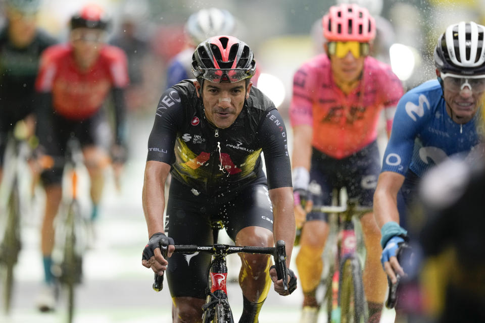 Richard Carapaz of Ecuador, center, and Spain's Enric Mas, right, cross the finish line of the eighth stage of the Tour de France cycling race over 150.8 kilometers (93.7 miles) with start in Oyonnax and finish in Le Grand-Bornand, France,Saturday, July 3, 2021. (AP Photo/Daniel Cole)