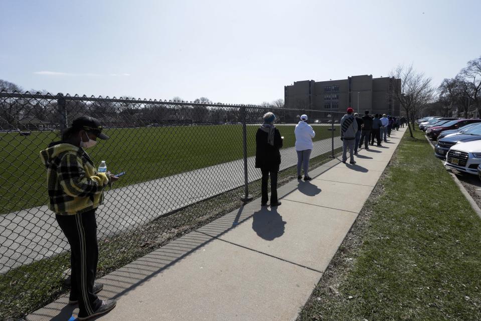 Voters observe social distancing guidelines as they wait in line to cast ballots at Washington High School while ignoring a stay-at-home order over the coronavirus threat to vote in the state's presidential primary election, Tuesday, April 7, 2020, in Milwaukee. (AP Photo/Morry Gash)