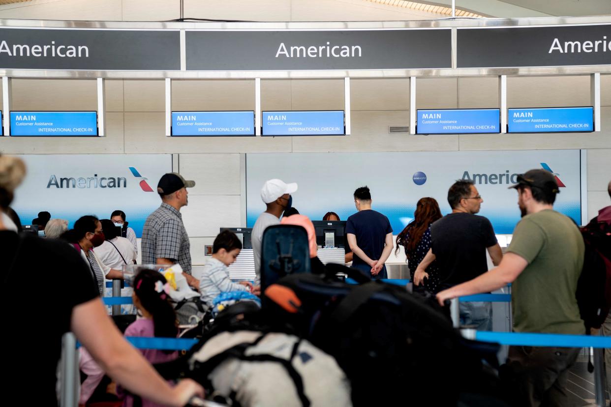 Travelers wait in line at an American Airlines counter at Ronald Reagan Washington National Airport in Arlington, Virginia, on July 2, 2022.