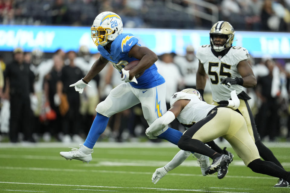 Los Angeles Chargers running back Isaiah Spiller (28) is tackled by New Orleans Saints safety Jordan Howden in the first half of an NFL football game in Inglewood, Calif., Sunday, Aug. 20, 2023. (AP Photo/Marcio Jose Sanchez)