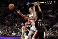 Sacramento Kings forward Keegan Murray, center, passes the ball as Portland Trail Blazers forward Kevin Knox II, left, and guard Shaedon Sharpe, right, defend during the first half of an NBA basketball game in Portland, Ore., Friday, March 31, 2023. (AP Photo/Steve Dykes)