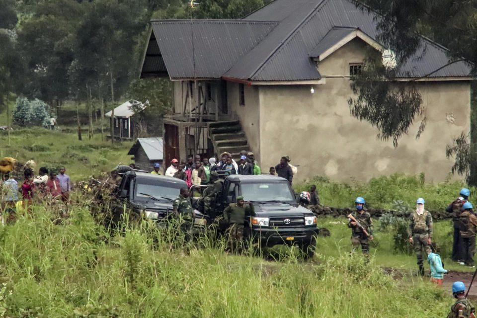 Local residents observe as United Nations peacekeepers guard the area near to where a U.N. convoy was attacked and the Italian ambassador to Congo killed, in Nyiragongo, North Kivu province, Congo Monday, Feb. 22, 2021. The Italian ambassador to Congo Luca Attanasio, an Italian Carabineri police officer and their Congolese driver were killed Monday in an attack on a U.N. convoy in an area that is home to myriad rebel groups, the Foreign Ministry and local people said. (AP Photo/Justin Kabumba)