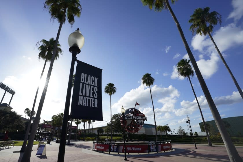 A Black Lives Matter banner hangs outside of the arena after a postponed NBA basketball first round playoff game between the Milwaukee Bucks and the Orlando Magic, Wednesday, Aug. 26, 2020, in Lake Buena Vista, Fla. The game was postponed after the Milwaukee Bucks didn't take the floor in protest against racial injustice and the shooting of Jacob Blake, a Black man, by police in Kenosha, Wisconsin. (AP Photo/Ashley Landis, Pool)